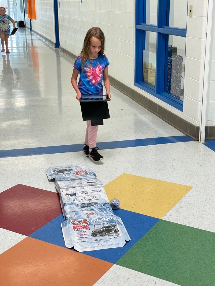 Student using a sphero robot to go up a ramp. 
